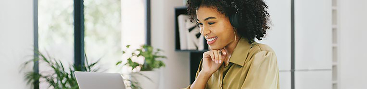 Femme regardant l’ordinateur portable et souriant