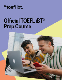 Two young men smile and laugh as they look at a laptop